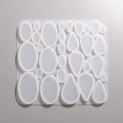 Silikon Gießformen verschieden große flache Ovale- und Tropfen-Formen von ca. 1 cm bis 5 cm. Darstellung Rückseite.