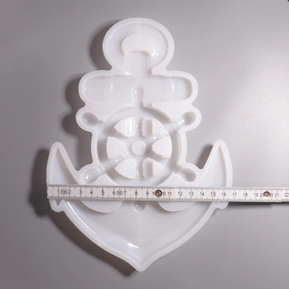 Weiße Silikon Gießform Anker mit Steuerrad Maritime Dekoration. Vorder Ansicht mit Lineal zu Ansicht. Hintergrund grau. 